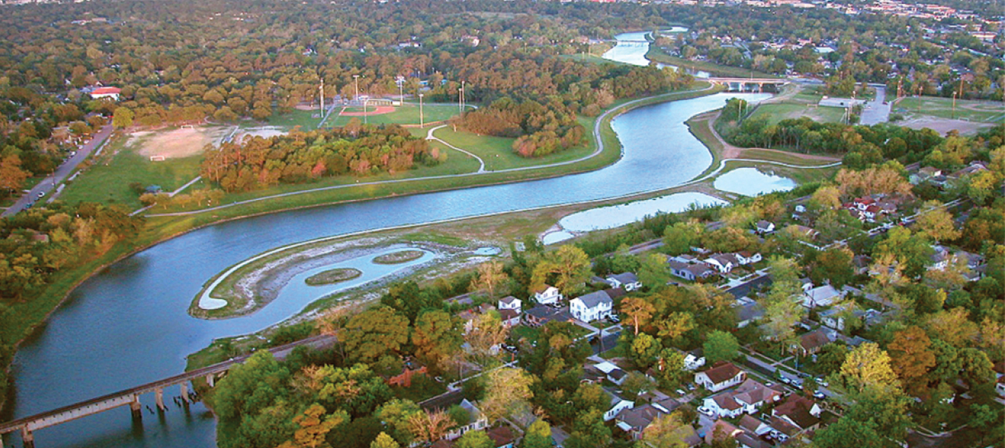 An aerial view of beautiful greenery with a river cutting through a suburb