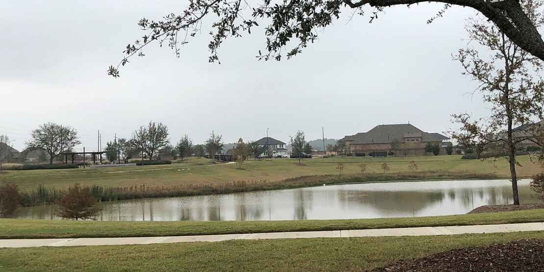 Elyson community homes by a small pond, as designed and developed by BGE, Inc.