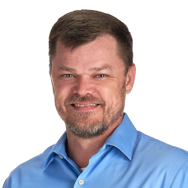 Professional headshot of Chad Criswell, smiling against a white background.