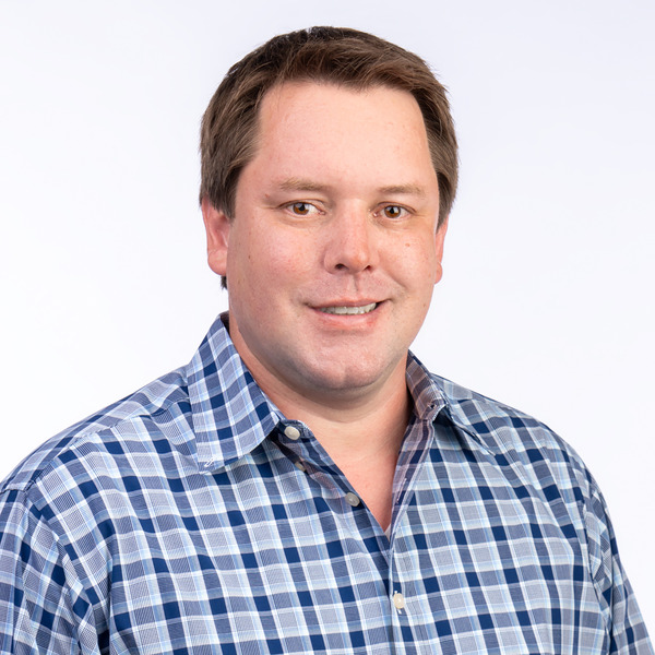 Professional headshot of Spencer McNab, smiling against a white background.